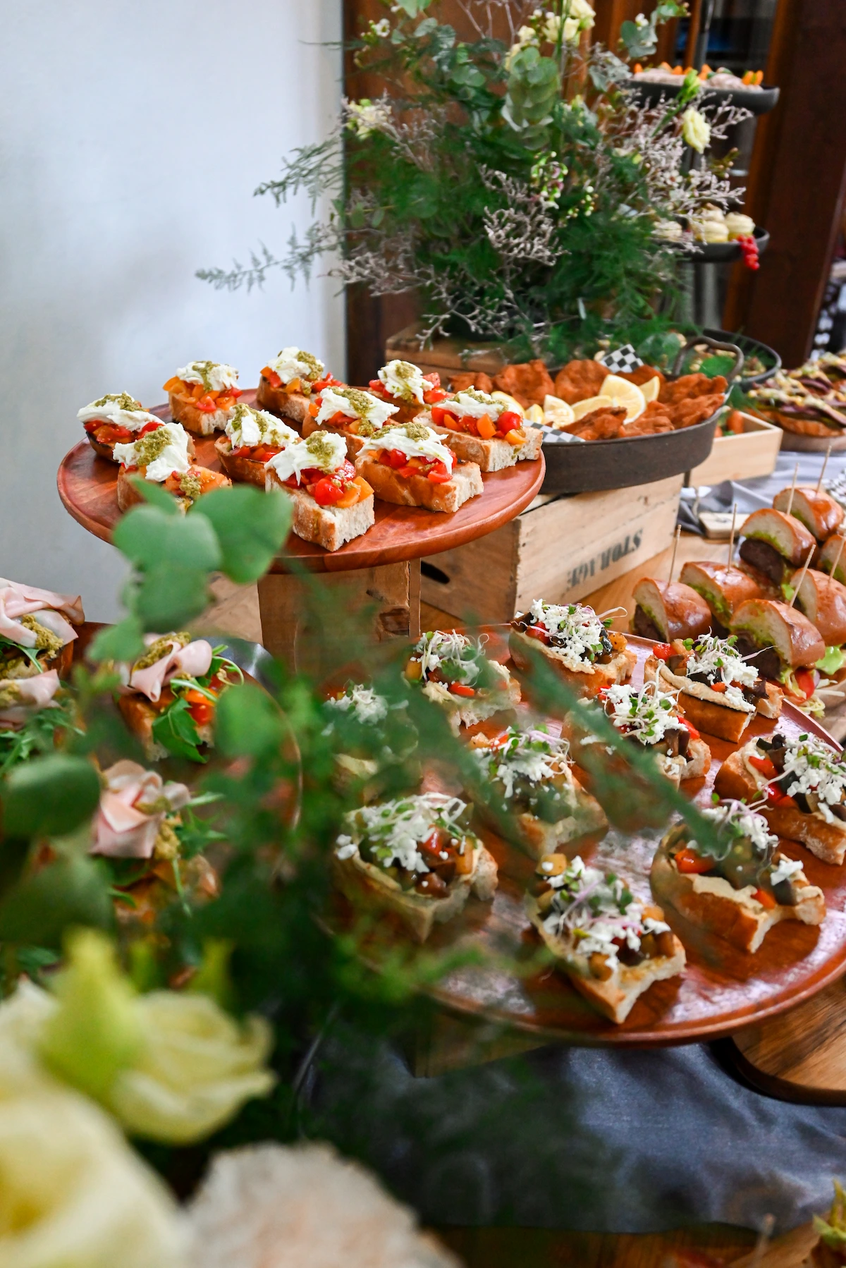 Prostřený stůl s bruschettami, mini burgery, taci a křídly na svatební hostině